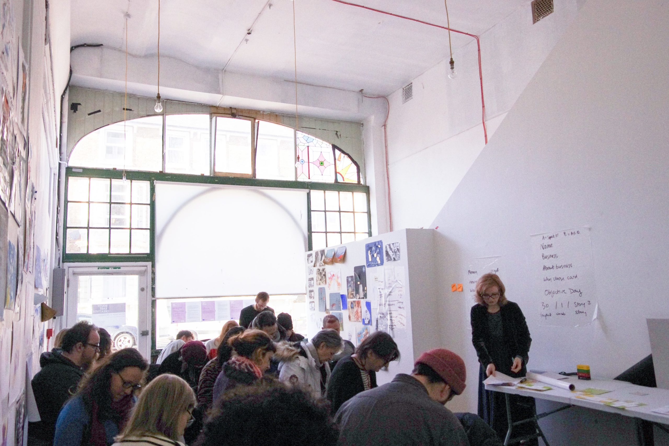 a lve workshop taking place in a large light flooded space with many old windows